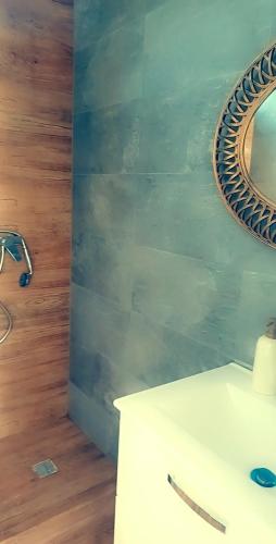 a bathroom with a mirror and a white sink at Garden Pypa in Vânătorii Mici