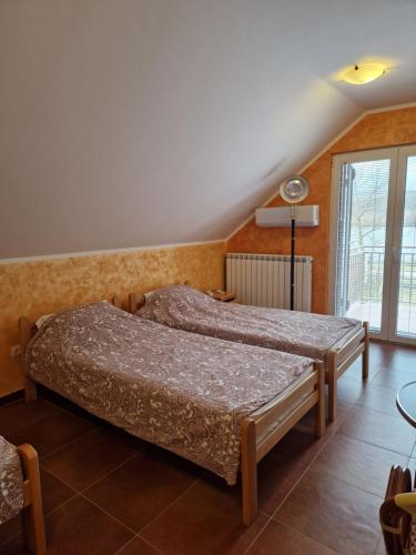 een slaapkamer met 2 bedden en een raam bij Apartmani Tina - Srebrno jezero in Zatonje