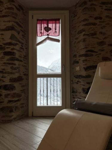 a room with a door with a window with a view at Trilocale con vista piste da sci in Villa Dalegno