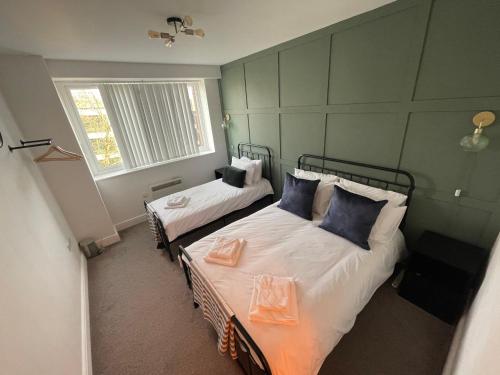 1 dormitorio con 2 camas y ventana en Electra house en Swindon