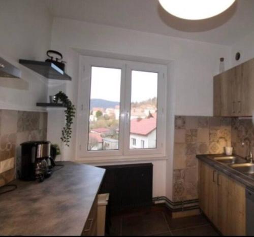 a kitchen with a large window and a kitchen counter at Charmant appartement en centre ville in Gérardmer