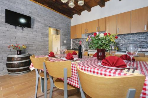 ein Esszimmer mit einem Tisch mit einer rot-weißen Tischdecke in der Unterkunft Holiday home Luka-sauna & jacuzzi in Privlaka