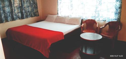 a bedroom with a bed with a red blanket and a window at Coorg nest Home stay in Madikeri