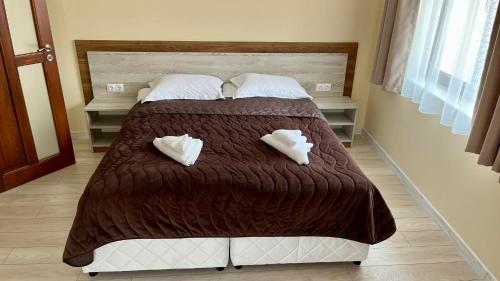 a bedroom with a bed with two towels on it at Къща за гости Михаела in Chepelare