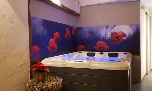 a jacuzzi tub in a bathroom with blue walls at Maison d'hôte avec sauna et jacuzzi à la campagne in Les Portes du Coglais