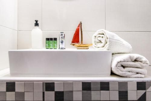 a bathroom sink with a towel and a laptop on it at Maria Rooms in Polychrono