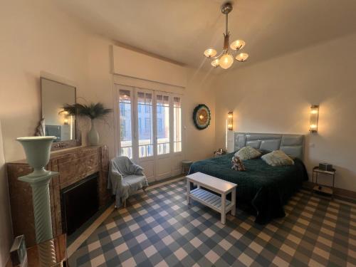 1 dormitorio con 1 cama y chimenea en VILLA MARYSE avec piscine privative, en Saint-Laurent-de-la-Salanque