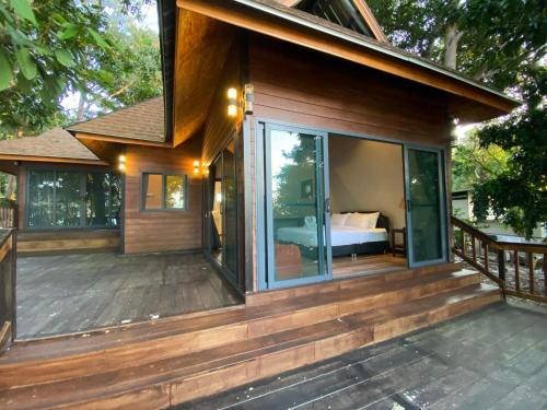 a house with a large deck with a bed at Cashewnut Cove in Ko Lipe