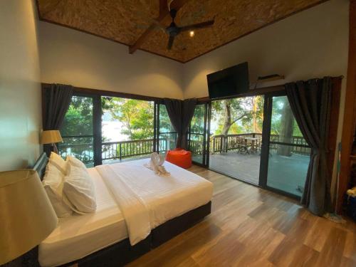 a bedroom with a large bed and a balcony at Cashewnut Cove in Ko Lipe