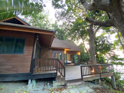 a house with a porch and a tree at Cashewnut Cove in Ko Lipe