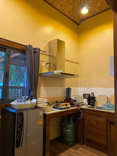 a kitchen with a refrigerator and a counter top at Cashewnut Cove in Ko Lipe
