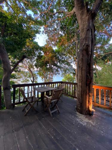 a wooden bench sitting on a deck next to a tree at Cashewnut Cove in Ko Lipe