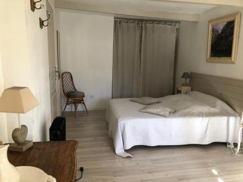 une chambre avec un lit, une table et une chaise dans l'établissement La Cigale bleue, à Villes-sur-Auzon