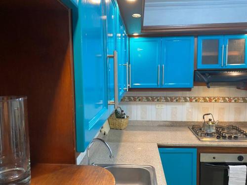 uma cozinha com armários azuis e um lavatório em Apartamento con garaje, sin escaleras y muy bien ubicado em Palmira