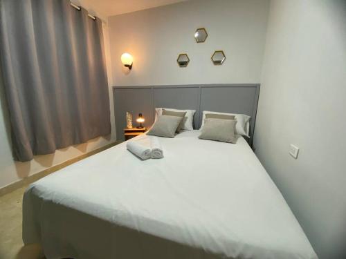 パルミラにあるApartamento con garaje, sin escaleras y muy bien ubicadoの窓付きの客室で、白い大型ベッド1台が備わります。