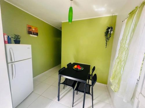 a small kitchen with a table and a refrigerator at Casa Vasquez in San Felipe de Puerto Plata