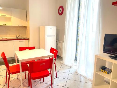 een keuken en eetkamer met een tafel en rode stoelen bij Gioberti in Turijn
