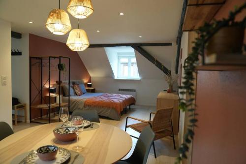 1 dormitorio con 1 cama, mesa y sillas en Cocon du Florival en Guebwiller