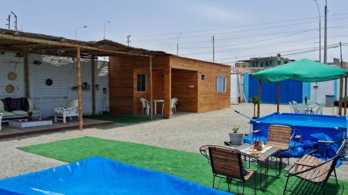 une maison avec une cour dotée d'une pelouse verdoyante dans l'établissement Cabañas de Punta Negra, à Punta Negra