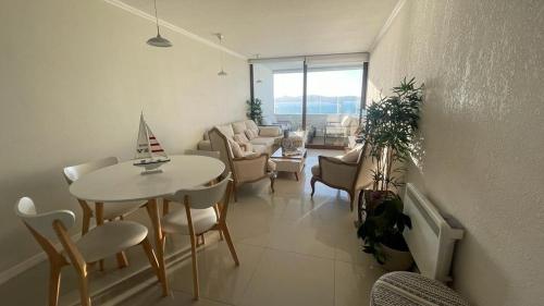 a living room with a table and chairs at Dpto vacacional serena in Coquimbo