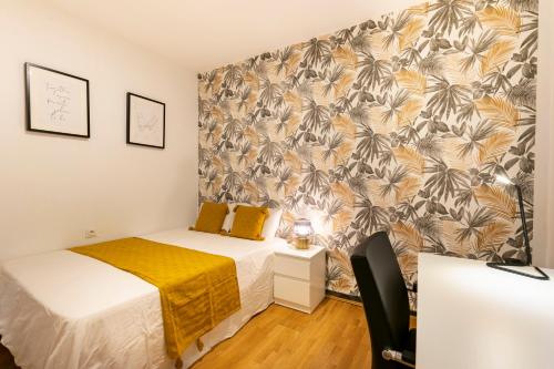 a bedroom with two beds and a wall with a tropical wallpaper at Casa DAURO in Granada