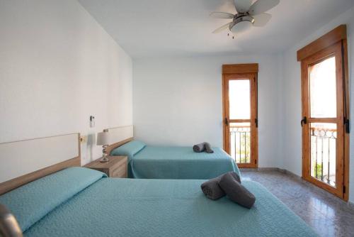 a bedroom with two beds and a ceiling fan at Casa Vistamar Varadero in Santa Pola