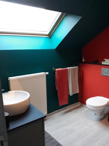 a bathroom with a sink and a toilet and a skylight at Couque cuivrée II in Dinant