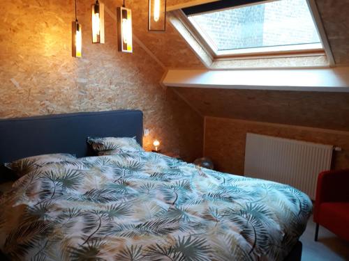 una camera con un letto blu e una finestra di Couque cuivrée II a Dinant