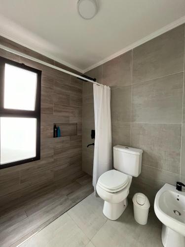 a bathroom with a toilet and a sink and a window at Lago Santa Ana in Santa Ana