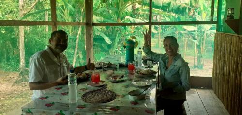 un hombre y una mujer sentados en una mesa en Refugio Rural Amazonas, en Iquitos