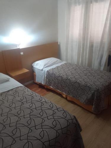 two beds in a hotel room withskirts at Hotel Alma di Mare in Mar del Plata