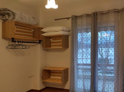 een kamer met een raam met een gordijn en een bed bij Kasoni Home , Απόλυτα κεντρικό διαμέρισμα μπροστά στη λίμνη in Kastoria