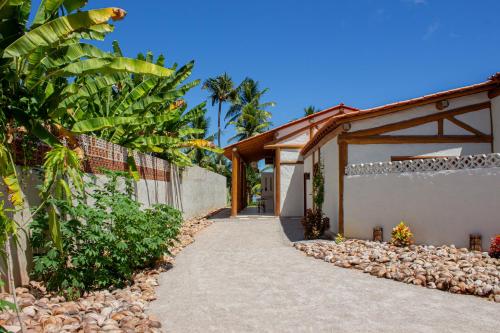 a driveway leading to a house with a fence at Casa Caroá - Chalé 1 in Japaratinga