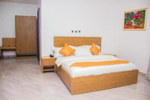 um quarto com uma grande cama de madeira com almofadas laranja em Villa Marina em Aso