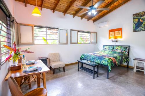 a bedroom with a bed and a table and chairs at Casitas Del Rio Riverfront Nature Lodge in Uvita