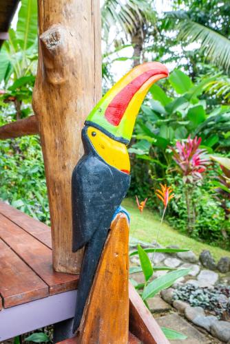 a wooden statue of a bird on a porch at Casitas Del Rio Riverfront Nature Lodge in Uvita