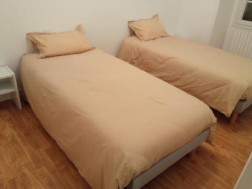 deux lits côte à côte dans une pièce dans l'établissement Gite proche Chateau-gontier, à Marigné-Peuton