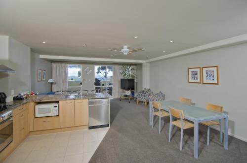 a kitchen and dining room with a table and chairs at Pavilion Beachfront Apartments in Mount Maunganui