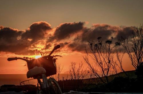 a bike parked in front of a sunset at Casa do Miradouro in Santa Bárbara