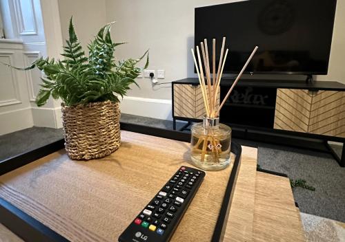 a remote control sitting on a table next to a tv at Trendy West End Apartment, Glasgow in Glasgow