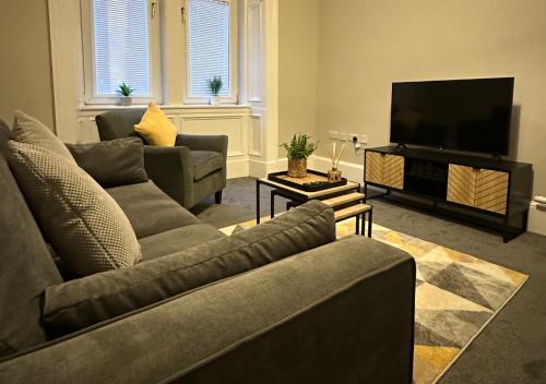 - un salon avec deux canapés et une télévision à écran plat dans l'établissement Trendy West End Apartment, Glasgow, à Glasgow