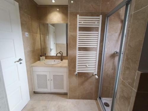 une salle de bain avec un lavabo et une douche avec un miroir dans l'établissement Villa privada Valle Golf Resort, à Murcie