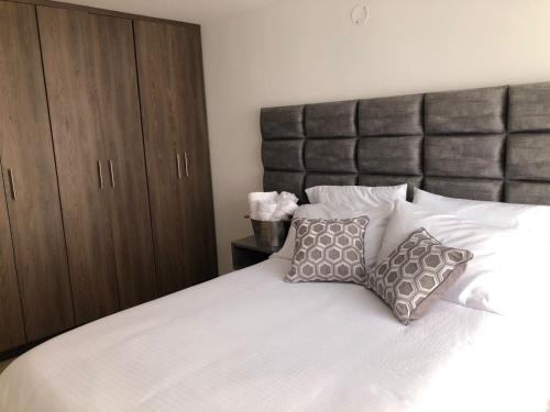 una camera da letto con un grande letto bianco con due cuscini di Beauté a Pereira