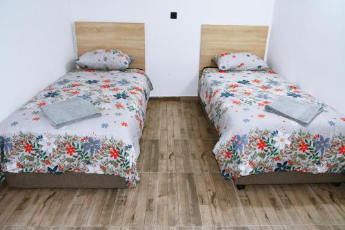 two beds sitting next to each other in a bedroom at Big Central Apartment in Skopje