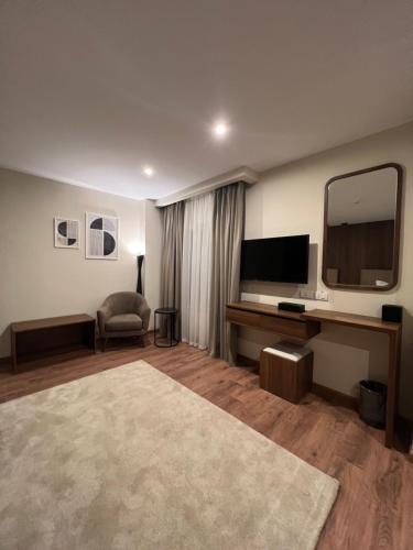 a living room with a television and a mirror at The Home Boutique Hotel Pyramids Inn in Cairo