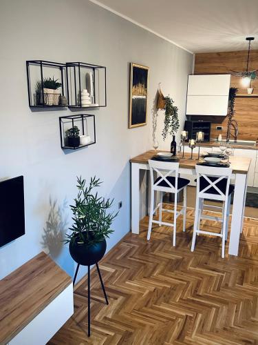 a room with a kitchen with a desk and chairs at TOP Apartman in Sombor