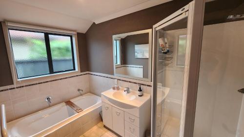 a bathroom with a sink and a tub and a shower at Huntington Honey in Hamilton