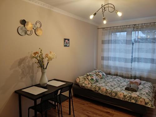 una piccola camera con letto e tavolo di Apartament GUNER a Bełchatów