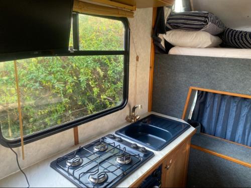 uma cozinha com um lavatório e uma janela num trailer em Hunter the Horsebox em Henley on Thames