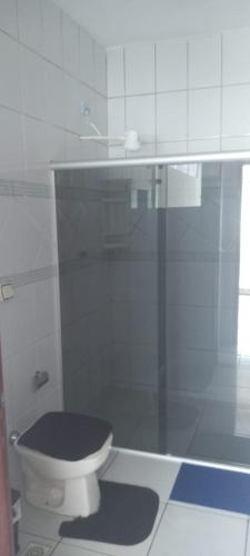 a bathroom with a toilet with a black seat at Apartamento da lília in Alto Caparao
